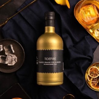 english craft rum tidefire luxury gold bottle black label ice glass orange peel garnish